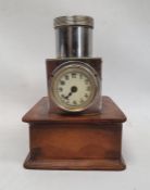 A steel-bodied clock with Arabic numerals to the enamel dial mounted on leatherette covered platform