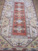 Oriental carpet manufacturer's wool rug in yellow, orange and blues, 216cm x 124cm