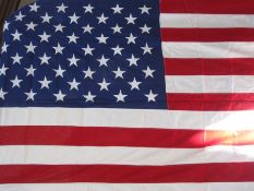 Two full-sized United States of America stars and stripes flags, one being enclosed in a glazed case