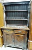 20th century oak Arts & Crafts-style dresser, the rack with moulded cornice above two shelves, the