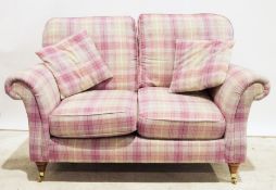 Modern two-seater sofa in pink tartan upholstery, on turned supports to brass caps and castors