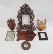 Metal ornate photograph frame with cherub surmount, carved treen and other items