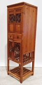 Eastern-style narrow cabinet with assorted cupboard doors and drawers, a brass and wire nursery