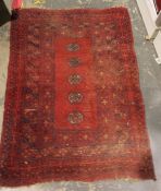 Red ground Eastern rug with five elephant's foot guls to the central field, stepped border, 110cm