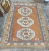Eastern style rug with terracotta ground, central field with three repeating cream ground hooked