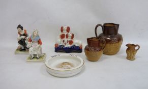 Three stoneware jugs, Staffordshire flatware spaniel group, pair of figures and a baby plate 'HRH