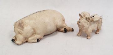 Cream painted cast iron pig money box the pig lying down and another smaller, the pig with wings (2)
