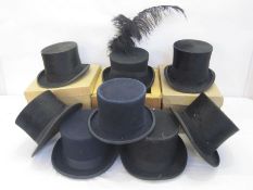 Eight various top hats, one trimmed as a funeral hat, one labelled 'Battersby & Co, London' and