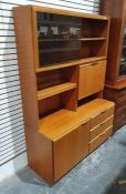 Mid century McIntosh teak lounge unit with sliding glass doors above fall and shelves, the base of