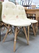 Set of four modern dining chairs with cream leather upholstered seats and back, on turned beech