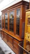 Large modern cherrywood bookcase with moulded cornice above four glazed doors enclosing shelves, the