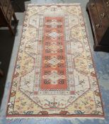 Eastern-style peach ground runner with repeating medallions to the central field, on stepped border,