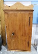 Vintage pine wall-hanging single door cabinet, the single door opening to reveal assorted shelves