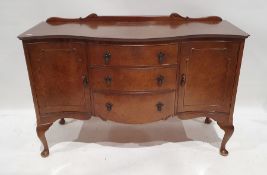 Early 20th century walnut serpent-fronted sideboard with three short drawers to centre flanked by