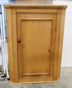Pine wall-hanging corner cupboard with single door enclosing shelves, 106cm high