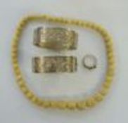 Two silver bangles, ivy-leaf engraved, a carved bone graduated bead necklace and a costume white