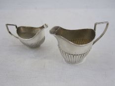 Two silver small half gadrooned cream jugs of helmet form, differing dates and makers, 3oz (2)