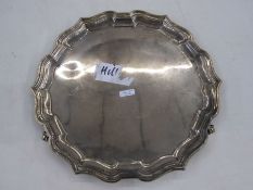Silver salver by Joseph Gloster Limited, Birmingham 1935 of shaped circular form, on three paw feet,