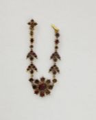Antique gold-coloured metal and almandine garnet bracelet having central flowerhead with foliate