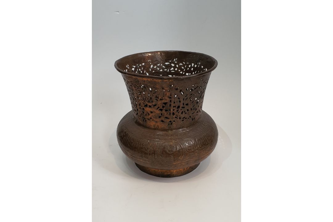 An Islamic copper pierced and repousse work lamp cover with a stylised calligraphic patterning. H. - Image 1 of 4