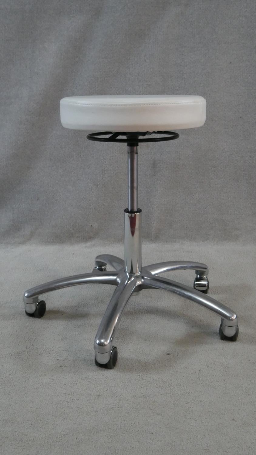 A pair of adjustable white vinyl stools on aluminium bases on casters. Makers label to the - Image 3 of 3