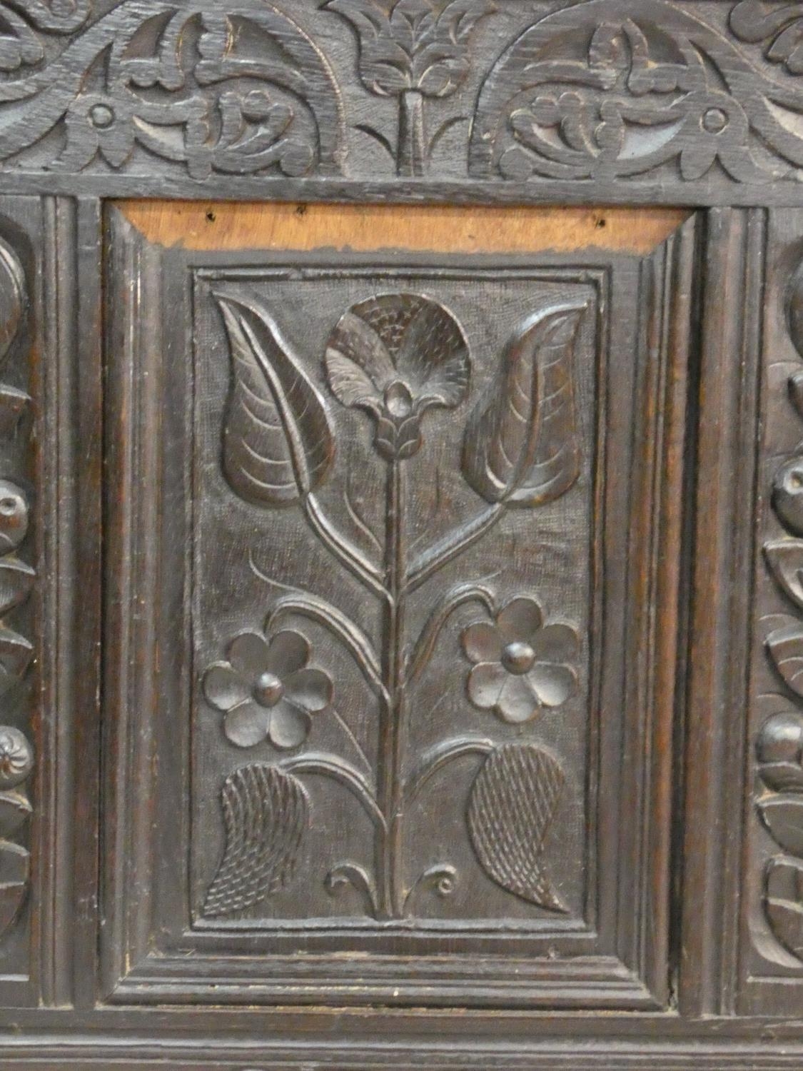 An antique country oak coffer with hinged lid above floral carved panels on block feet. H.75 L.136 - Image 5 of 8
