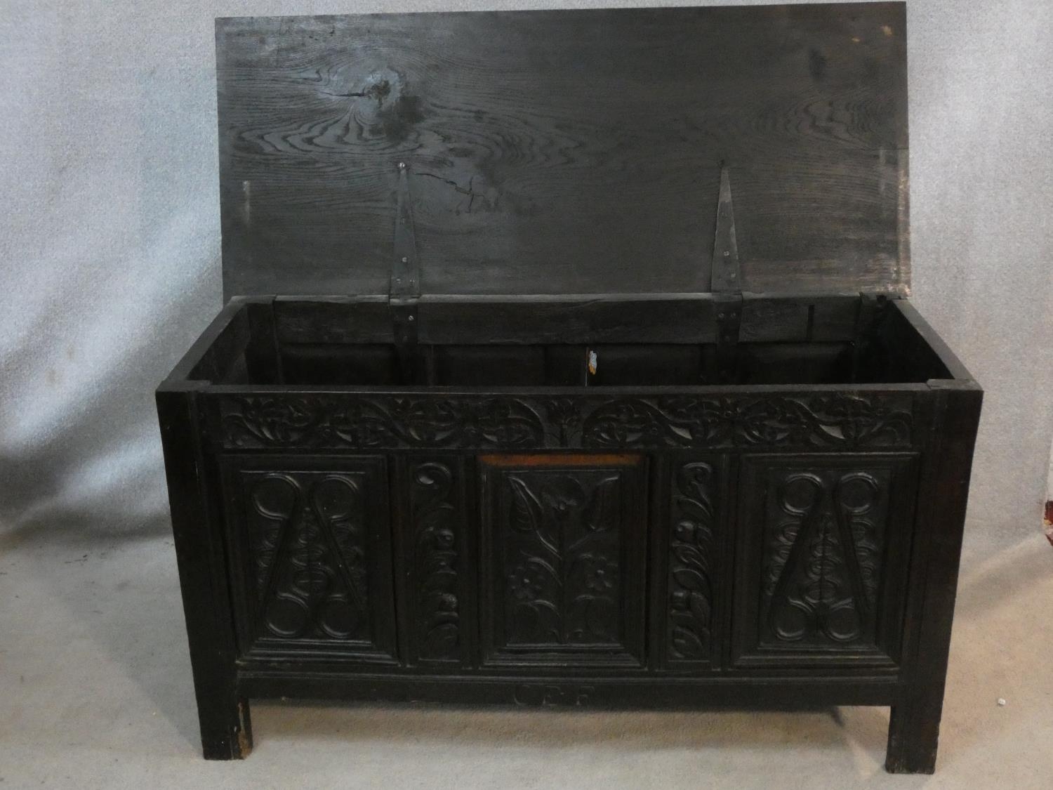 An antique country oak coffer with hinged lid above floral carved panels on block feet. H.75 L.136 - Image 2 of 8