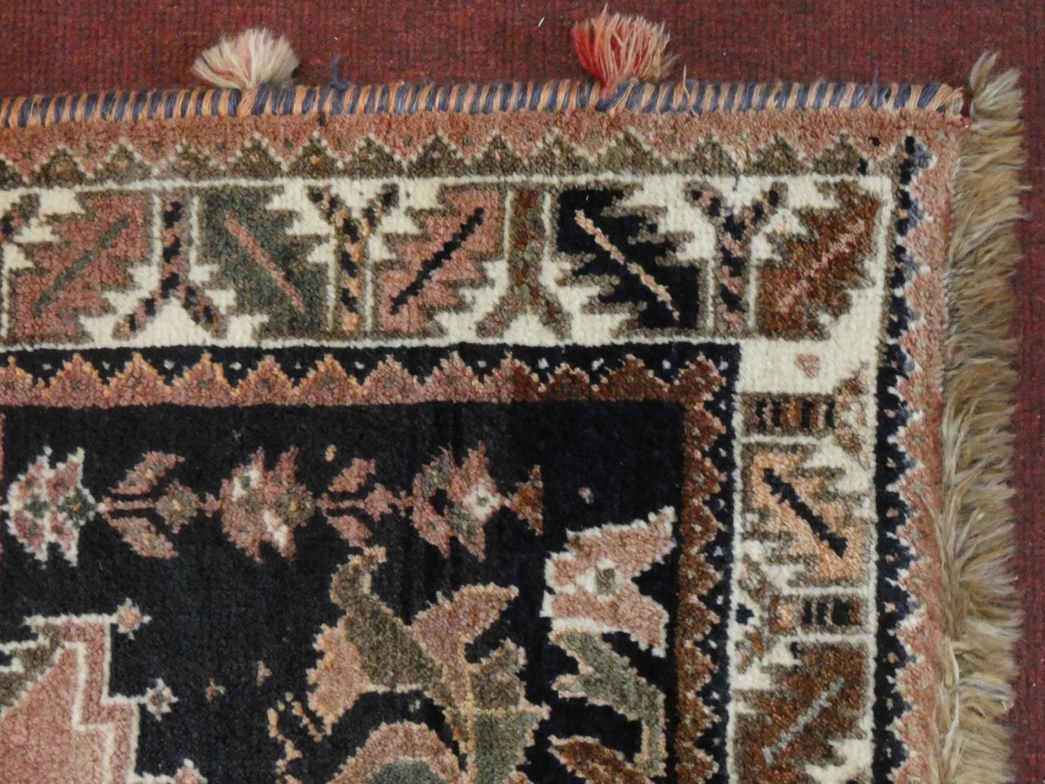 A Persian carpet with triple hooked central medallions with stylised bird motifs on the madder - Image 3 of 4