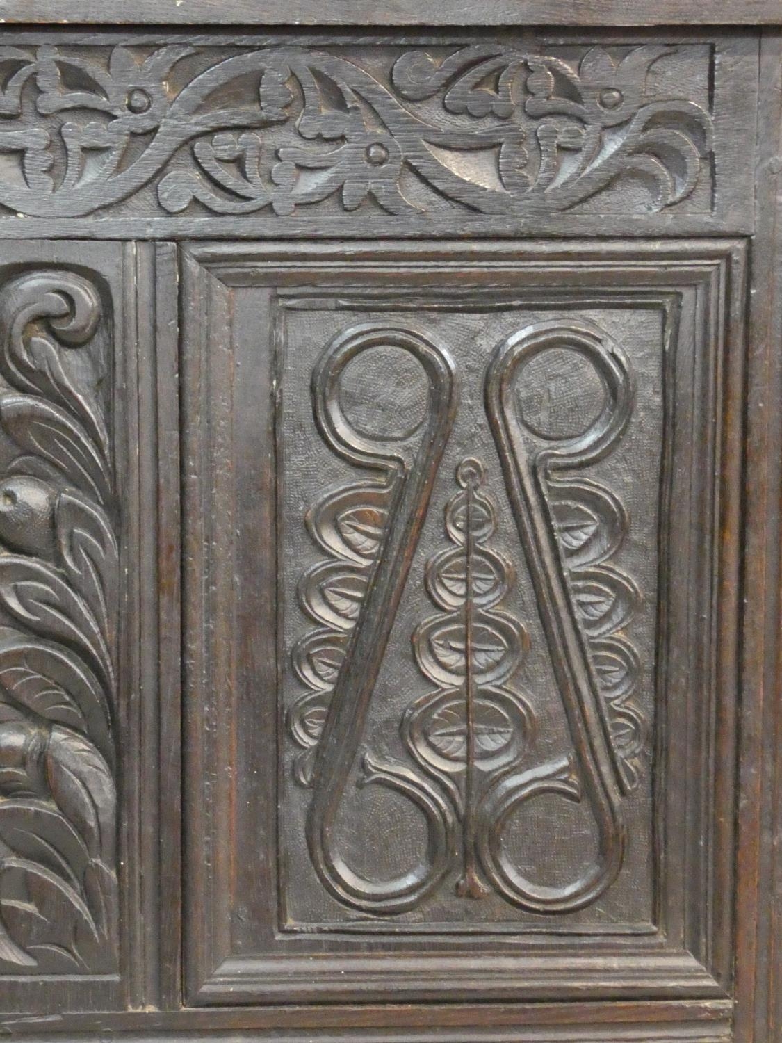 An antique country oak coffer with hinged lid above floral carved panels on block feet. H.75 L.136 - Image 6 of 8