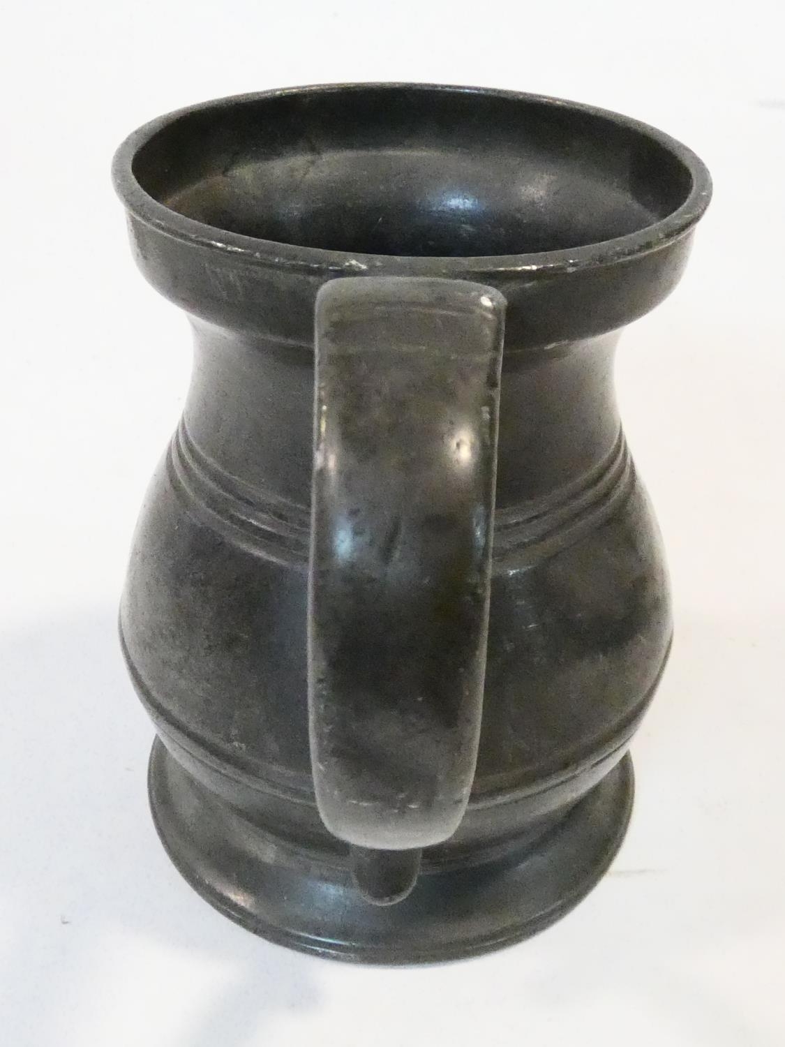 A collection of antique pewter items. Including plates, measures, pepper shaker, jug and tankards. - Image 12 of 27