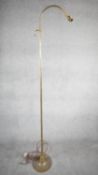 A vintage solid brass height adjustable arched design standard lamp with weighted circular base