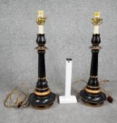 A pair of vintage lacquered metal table lamps with gilded detailing and floral design around the