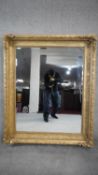 A 19th century giltwood wall mirror with carved floral decorated frame. H.129 W.106