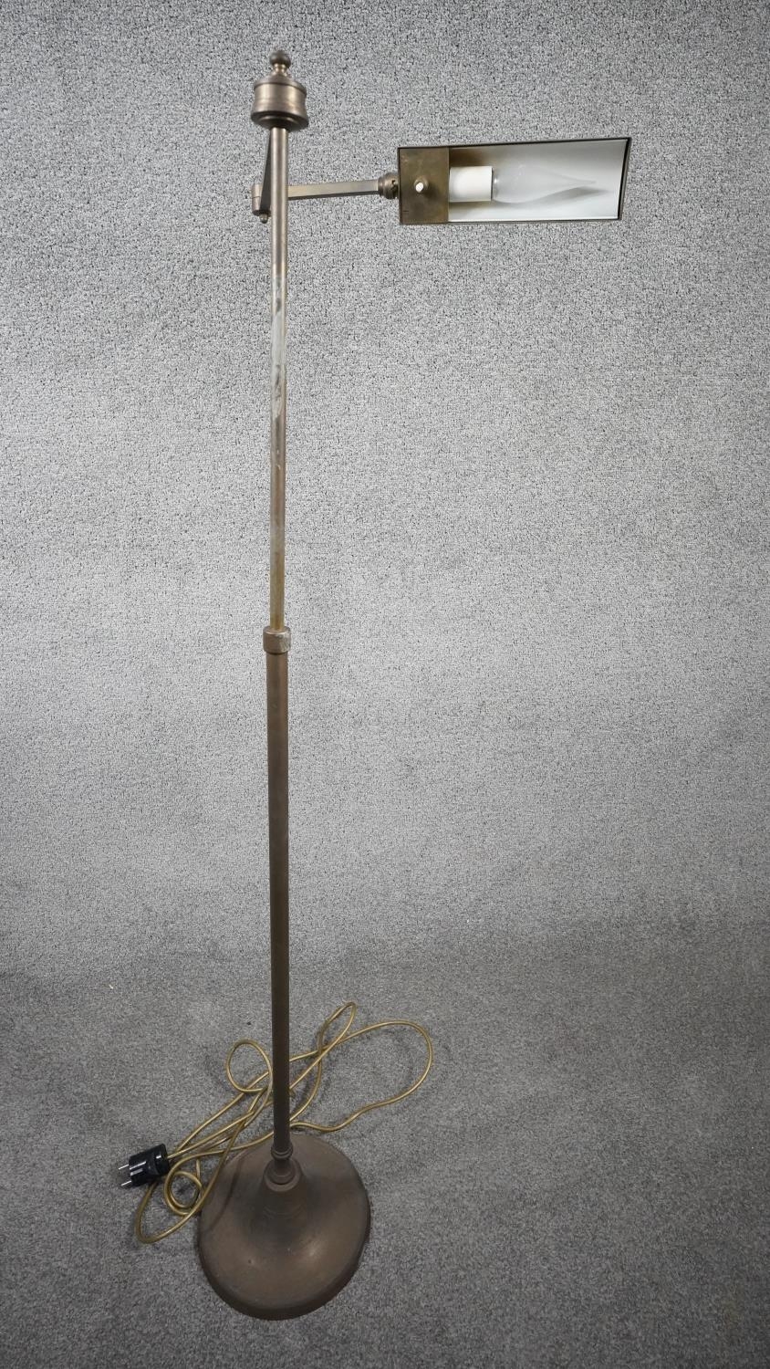 A vintage solid brass height adjustable swing arm floor lamp with triangular shade and circular