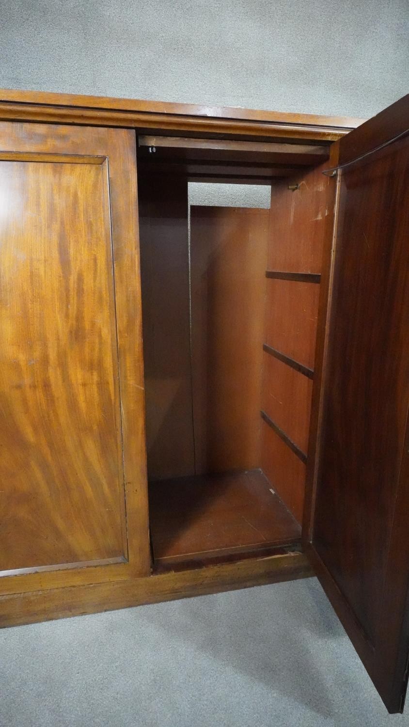 An mid 19th century mahogany linen cupboard with central panel doors flanked by two banks of four - Image 9 of 14