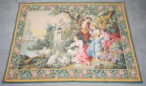 A vintage Aubusson style tapestry wall hanging depicting a garden with people by a lake with sheep