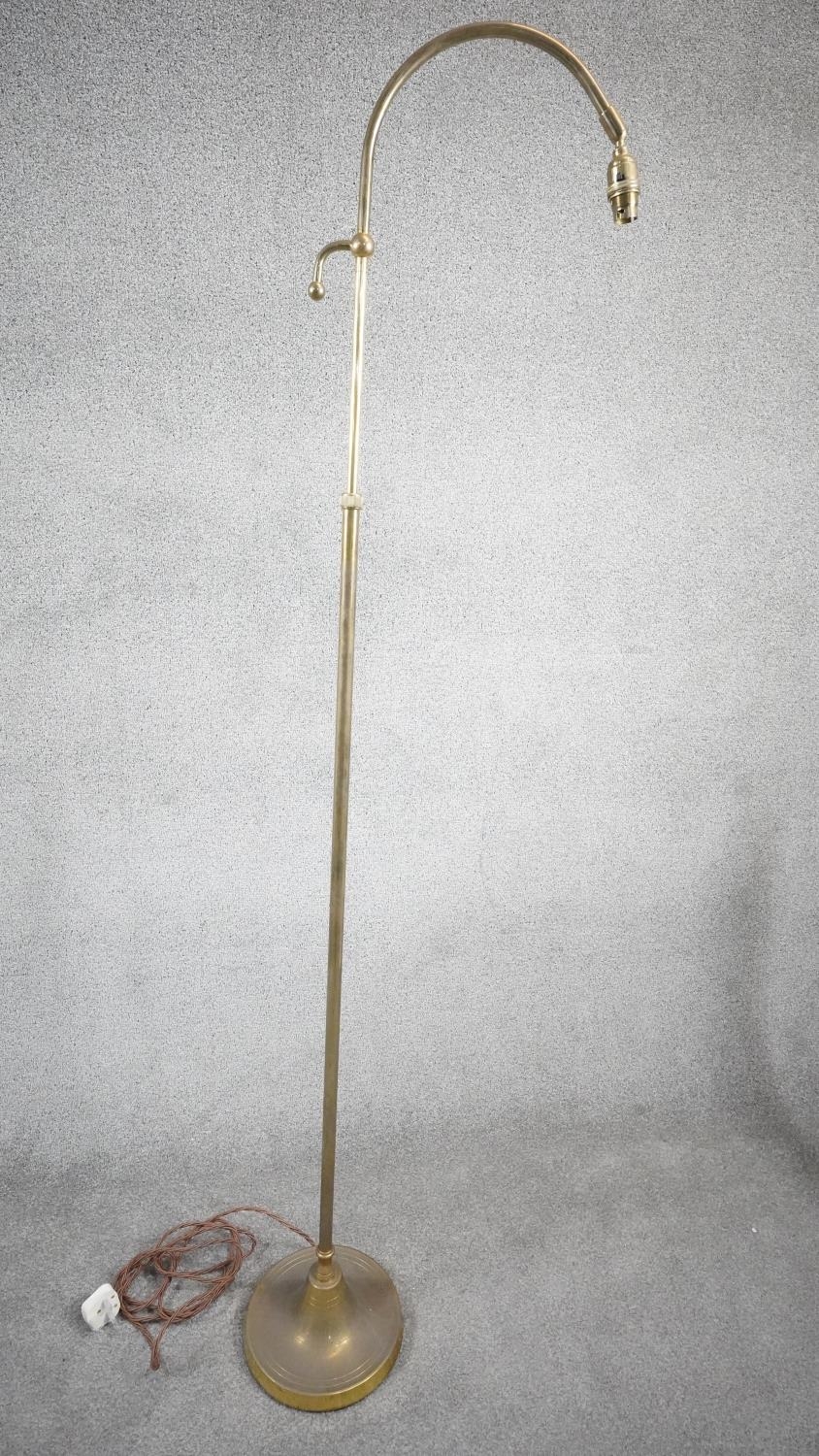A vintage solid brass height adjustable arched design standard lamp with weighted circular base