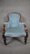 A Victorian mahogany framed armchair in deep buttoned upholstery on baluster turned supports. H.