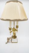 A gilt metal twin branch table lamp with cherub base holding flames aloft. H.64cm