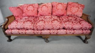 A mid century mahogany Georgian style bergere sofa with caned back and sides on squat cabriole