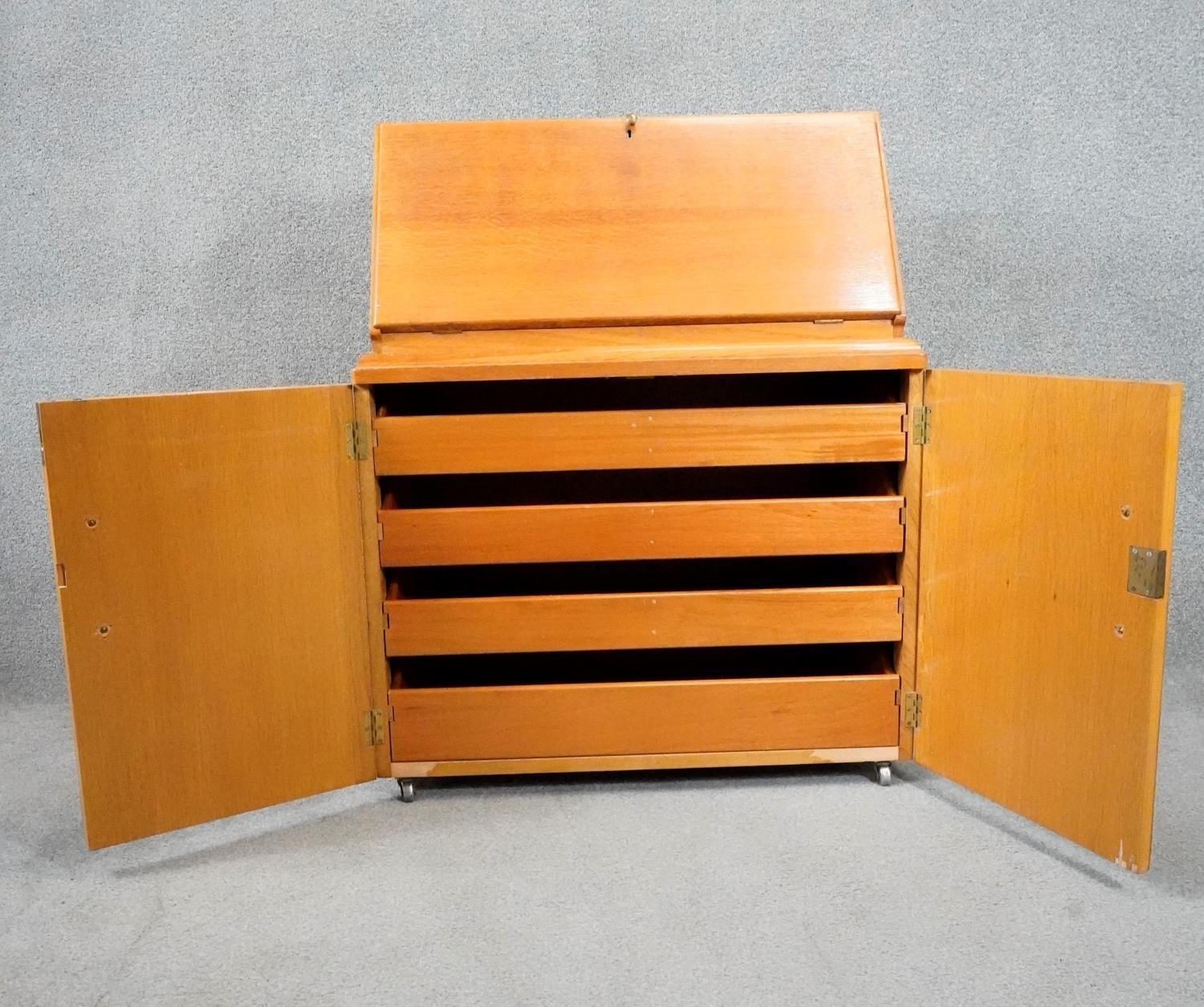 A vintage light oak bureau with fitted interior above panel doors enclosing slides. H.95cm - Image 4 of 5