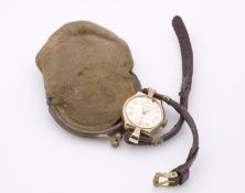 A vintage J W Benson 9 carat gold cased ladies watch along with a gun metal pocket watch in suede