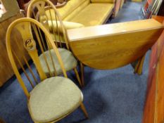 AN ERCOL WINSOR DROPLEAF TABLE WITH TWO 'SWAN' HOOPBACK CHAIRS