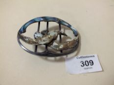 A STERLING SILVER AND ENAMEL BELT BUCKLE IN THE FORM OF A BIRD IN FLIGHT OVER WATER IN AN ART