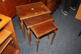 A WALNUT GLASS TOPPED NEST OF TABLES