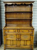 A SOLID OAK CARVED WELSH STYLE DRESSER WITH PLATE RACK H-182 W-122 CM