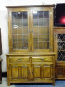 A SOLID OAK GLAZED BOOKCASE WITH TWO DRAWERS AND CUPBOARDS BELOW H-189 W-118 CM