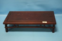 A CHINESE HARDWOOD SCHOLAR'S TABLE TOP LOW STAND RAISED ON FOUR LEGS