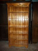 A TALL SOLID PINE BOOK SHELF/CASE