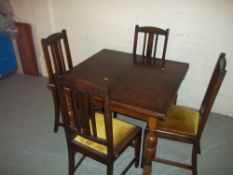 A 1920 OAK DRAW LEAF TABLE AND FOUR CHAIRS